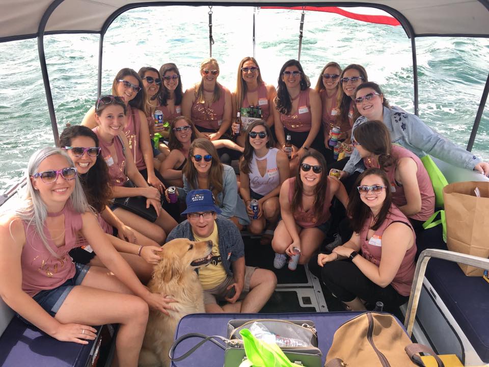 Image may contain: 18 people, people smiling, people sitting, sky, ocean, outdoor and water